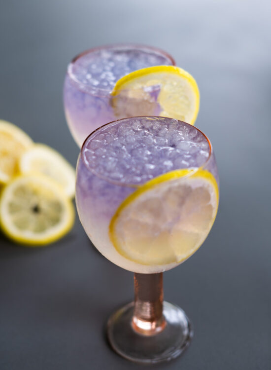Lemon Empress Sparkler in pink hue goblets with slices of lemon as a garnish