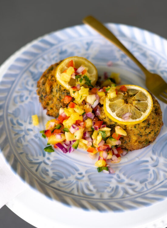 Pineapple Salsa plated with two crab cakes on a plate.